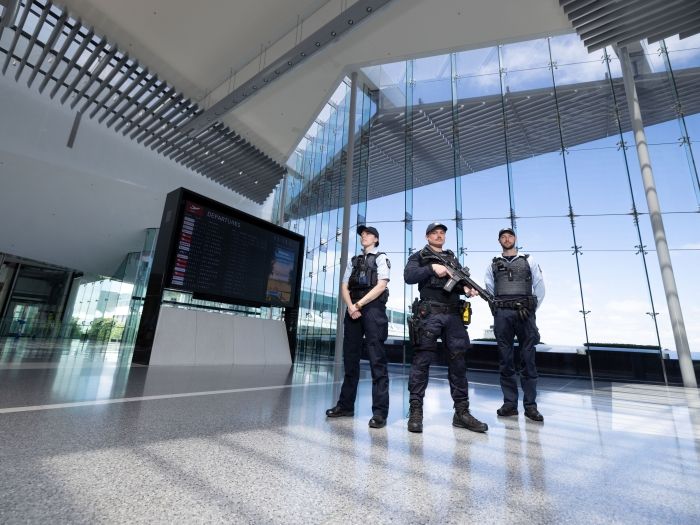 Three uniformed and armed police officers patrolling Canberra Airport