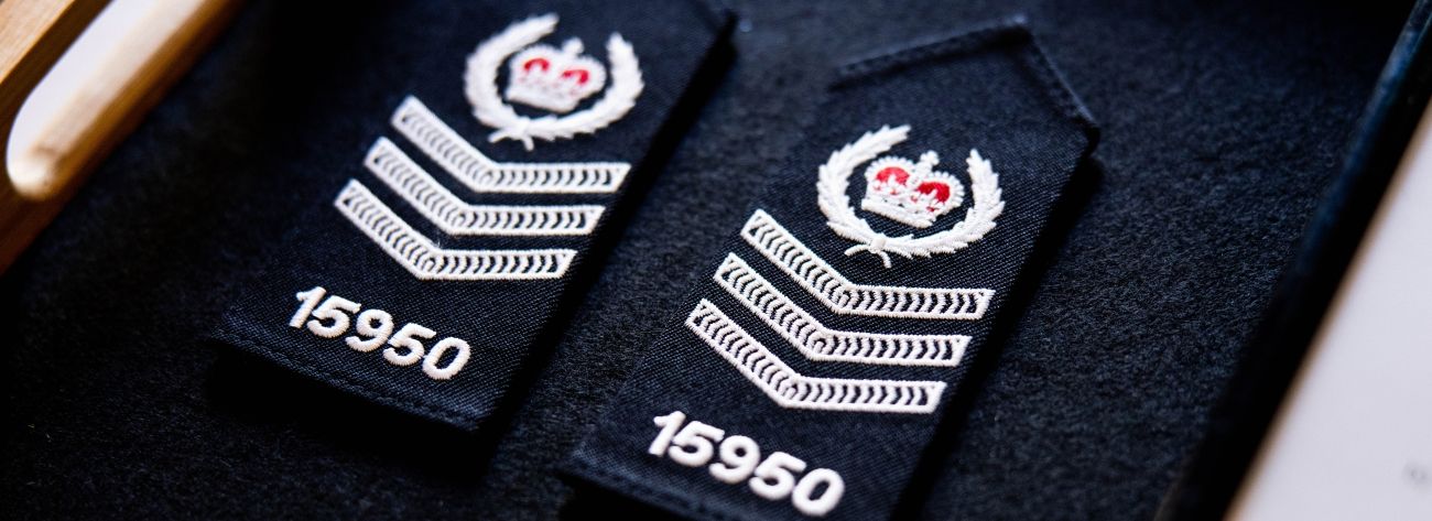 AFP Insignia shoulder badge with a crown and three white chevrons pointing down