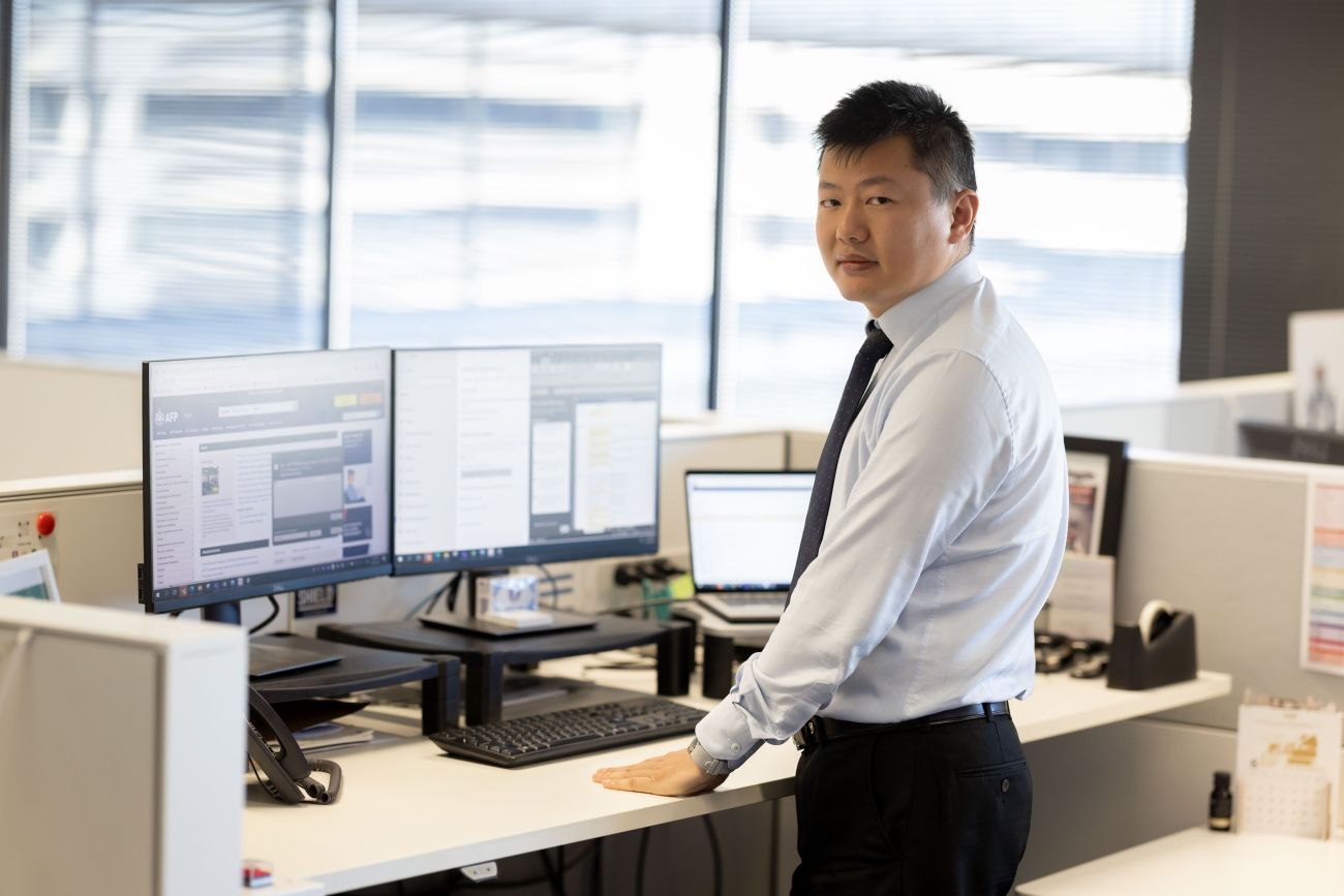 Man in a suit at a standing office desk